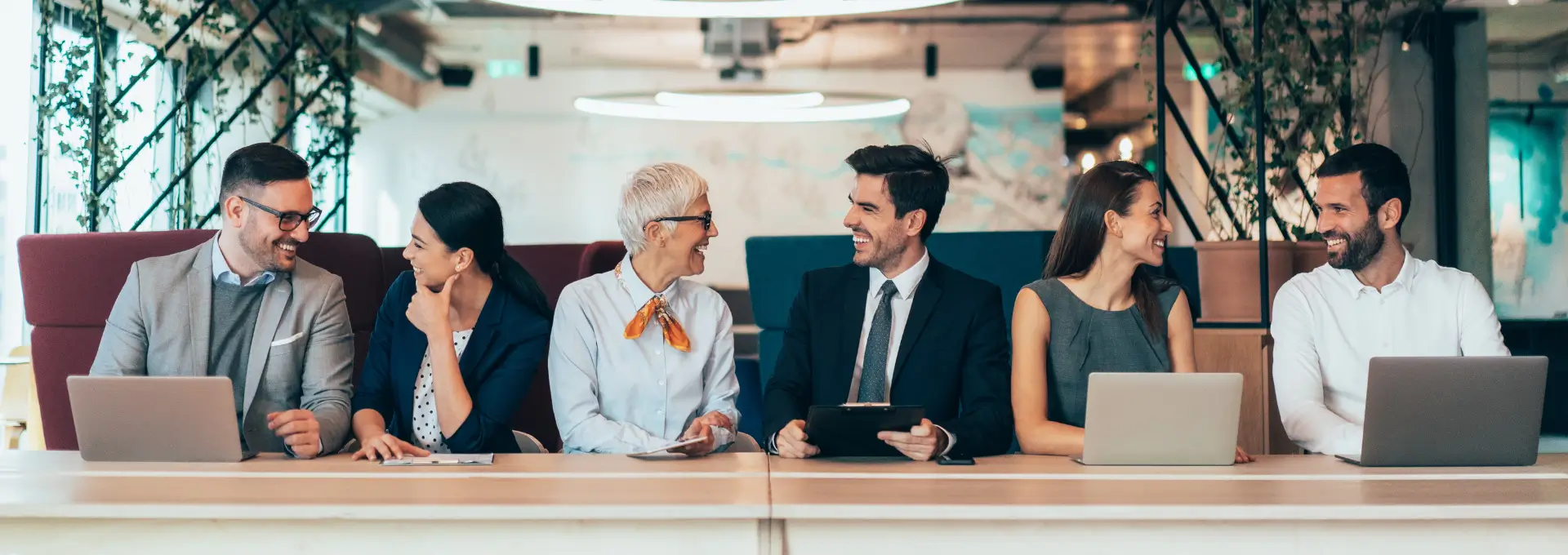 Group of business people sitting at a table smiling at each other